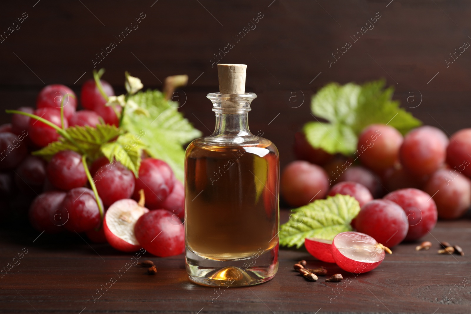 Photo of Bottle of natural grape seed oil on wooden table. Organic cosmetic