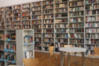 Blurred view of bookshelves and table in library