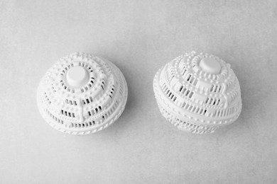 Dryer balls for washing machine on light grey table, flat lay