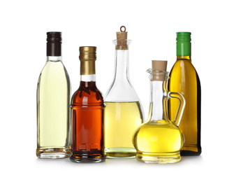Photo of Different sorts of cooking oil in bottles isolated on white