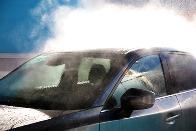 Clean wet automobile at professional car wash