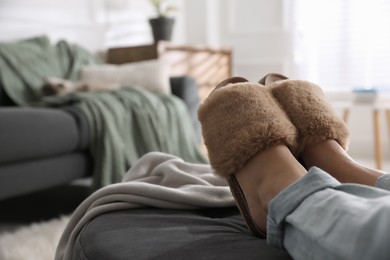 Photo of Woman wearing stylish soft slippers at home, closeup