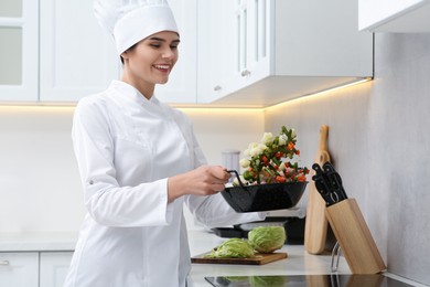 Photo of Professional chef cooking delicious salad in kitchen