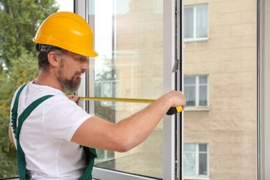 Construction worker installing new window in house