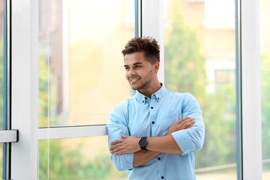 Photo of Portrait of handsome young man looking out window indoors