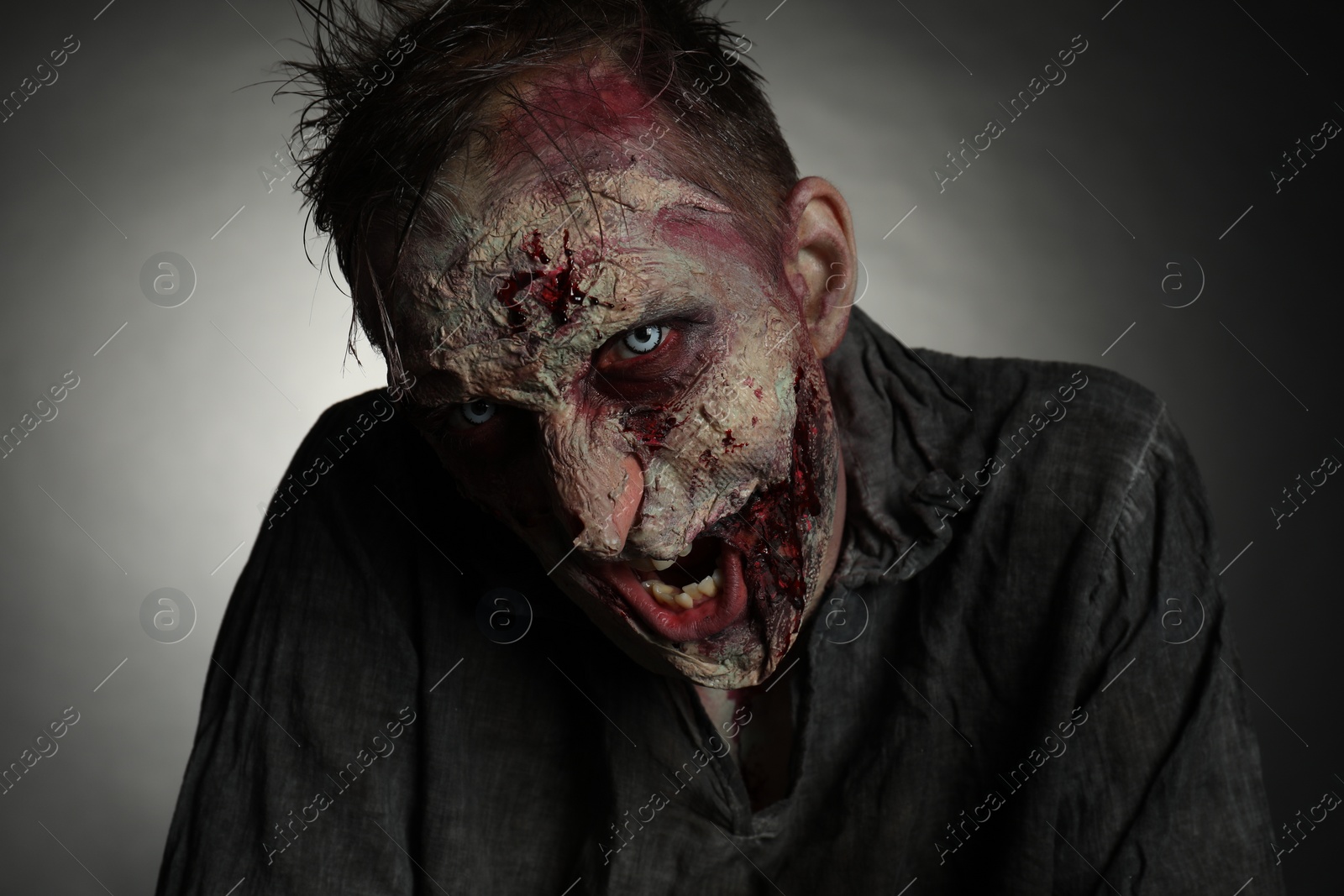 Photo of Scary zombie on dark background. Halloween monster