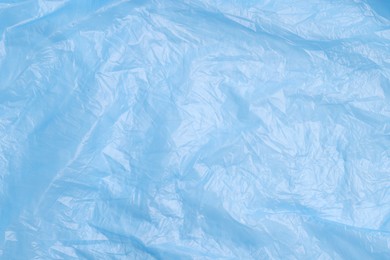 Photo of Crumpled light blue plastic bag as background, top view