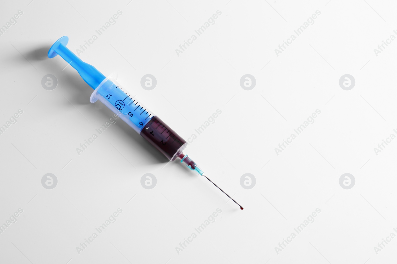 Photo of Plastic syringe with blood on white background