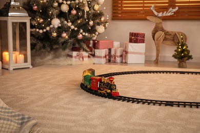 Photo of Colorful train toy in room with Christmas decorations