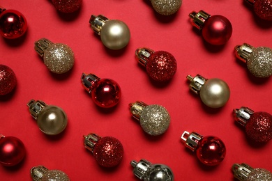 Photo of Colorful Christmas balls on red background, flat lay