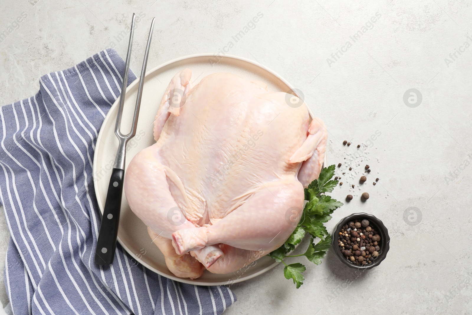 Photo of Fresh raw chicken with spices and fork on light grey table, flat lay