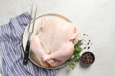 Photo of Fresh raw chicken with spices and fork on light grey table, flat lay