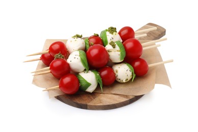 Photo of Caprese skewers with tomatoes, mozzarella balls, basil and pesto sauce on white background