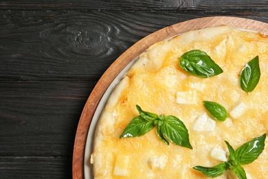 Fresh tasty homemade pizza on wooden background, top view