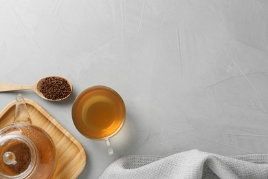 Buckwheat tea and granules on light grey table, flat lay. Space for text