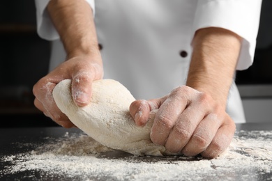Man kneading dough for pastry on table