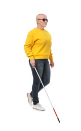 Photo of Mature blind person with long cane walking on white background