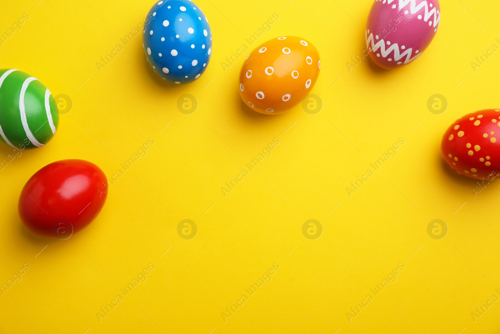 Photo of Decorated Easter eggs and space for text on color background, top view