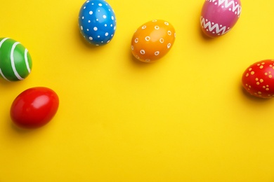 Photo of Decorated Easter eggs and space for text on color background, top view