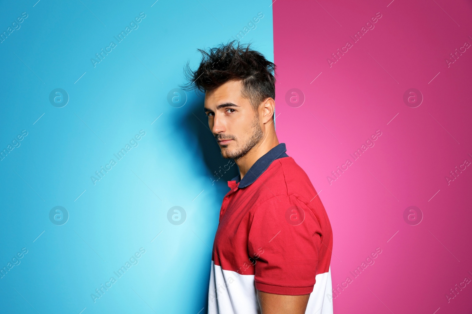 Photo of Young man with trendy hairstyle posing on color background