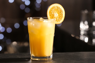 Delicious cocktail with orange on bar counter