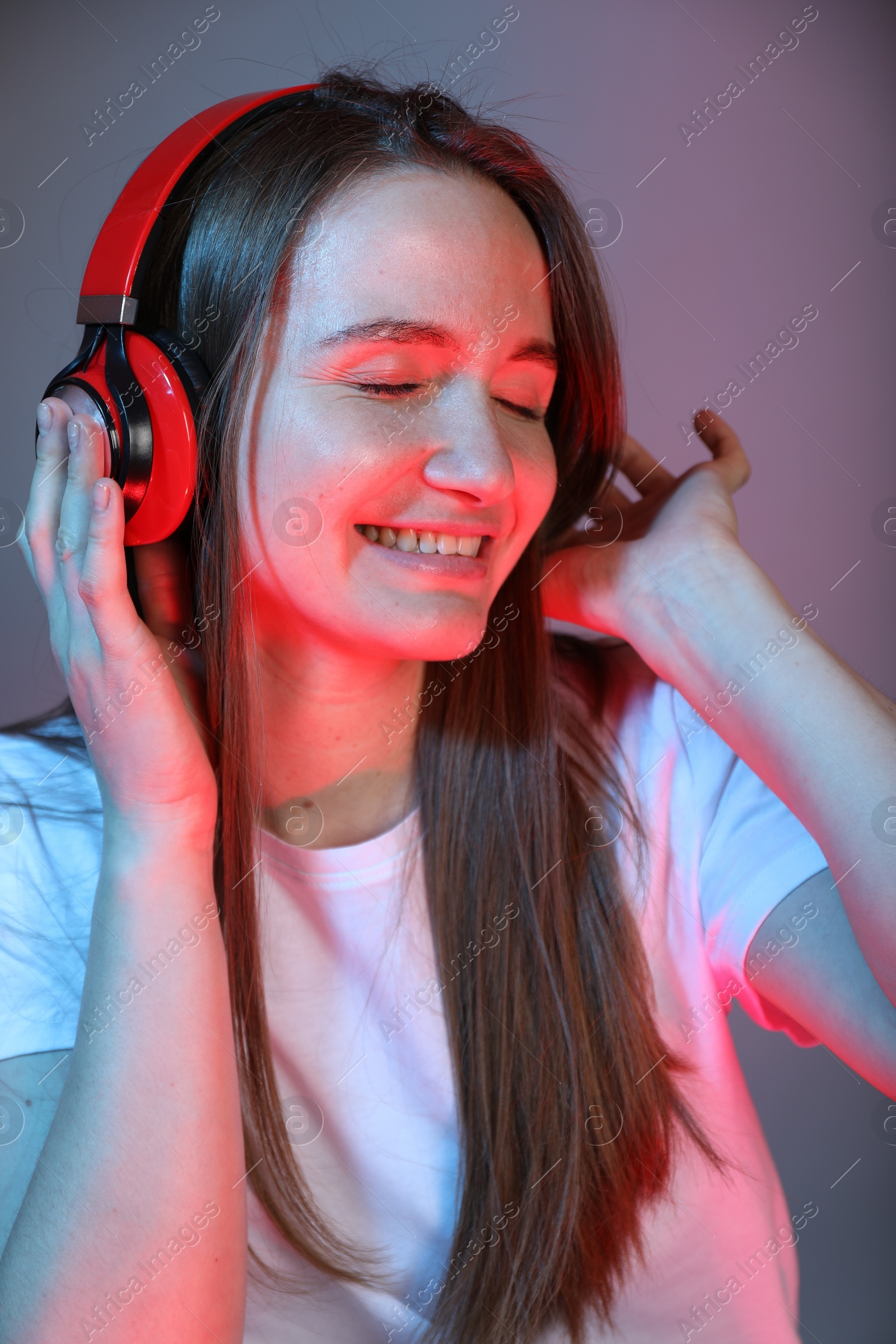 Photo of Portrait of beautiful woman with headphones on color background