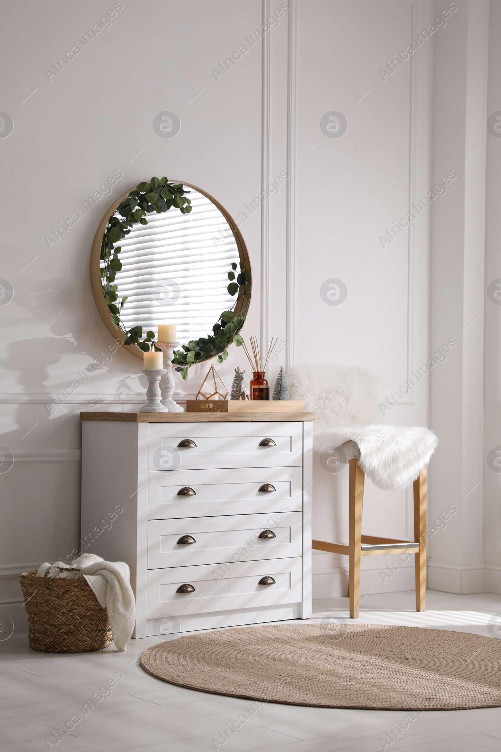 Photo of Modern room interior with chest of drawers and mirror on white wall