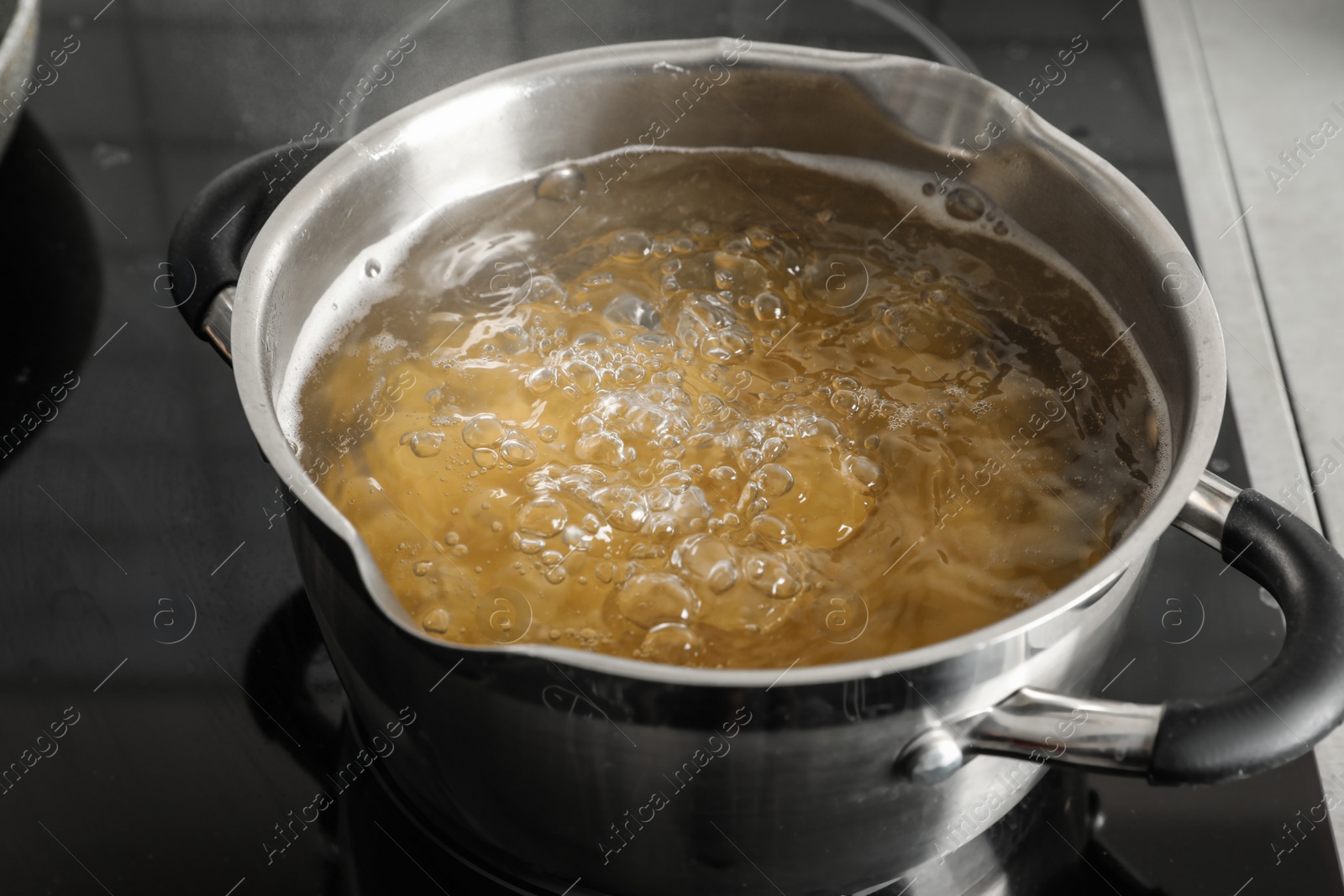 Photo of Cooking pasta in pot on electric stove