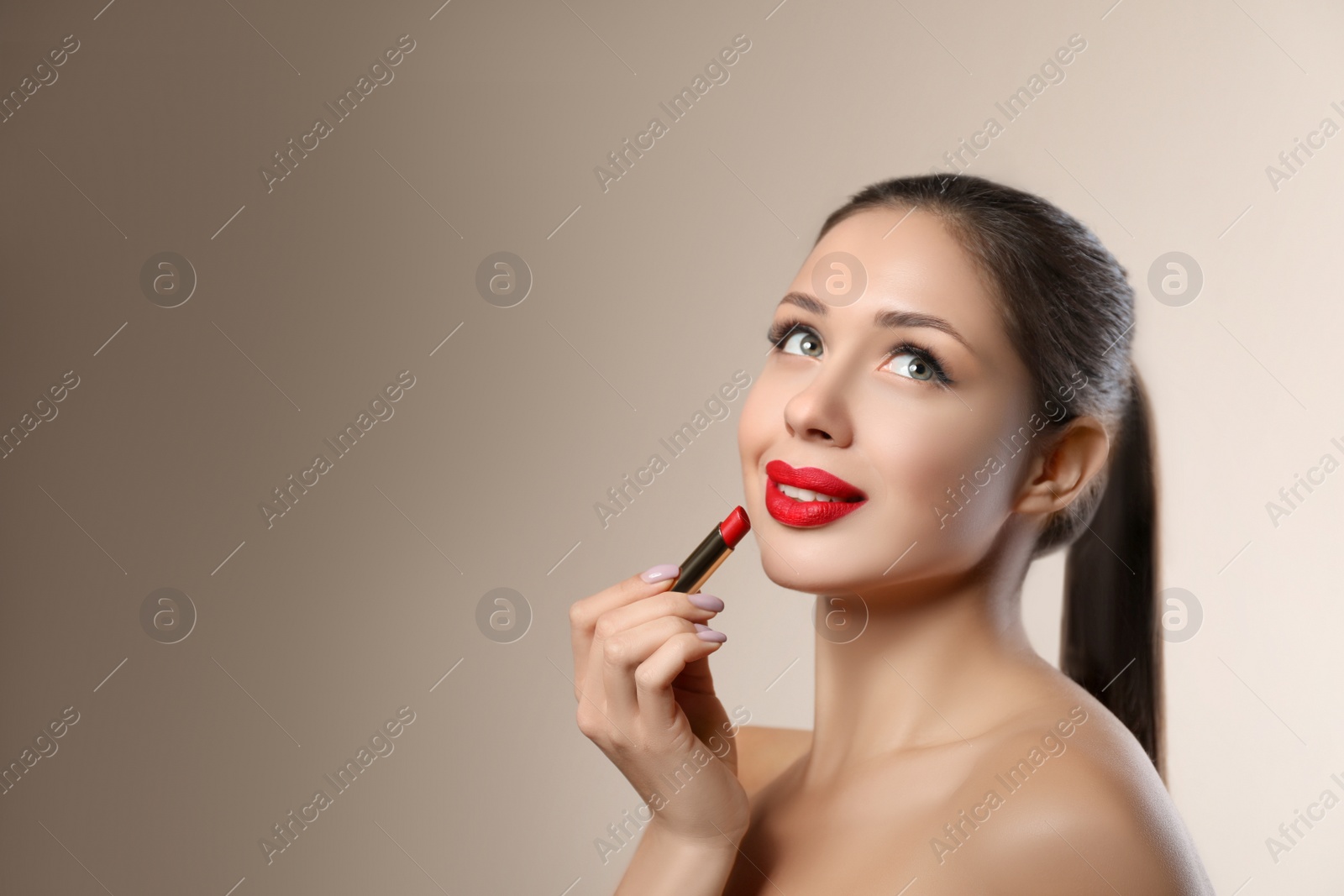 Photo of Beautiful woman with red lipstick on beige background, space for text