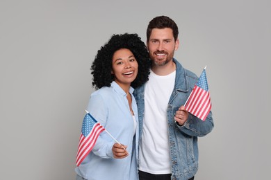 4th of July - Independence Day of USA. Happy couple with American flags on grey background