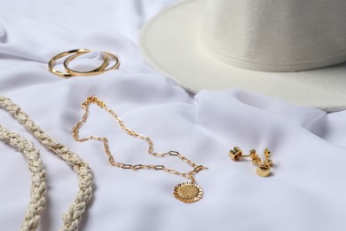 Photo of Different elegant bijouterie and accessories on white cloth