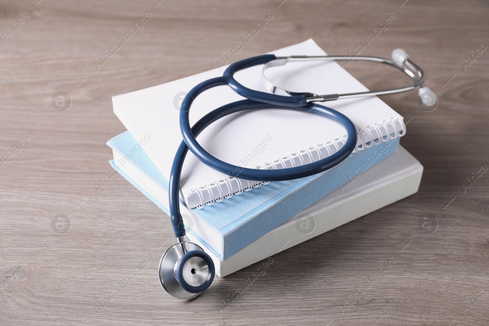 Photo of Student textbooks and stethoscope on wooden table. Medical education