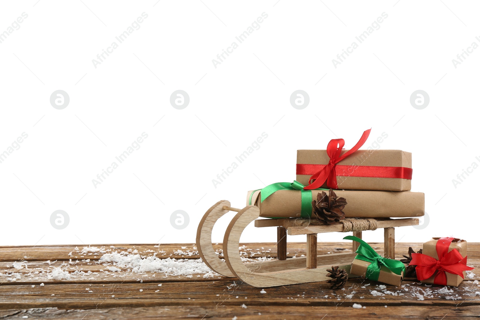 Photo of Decorative sleigh with Christmas gift boxes on wooden table. Space for text