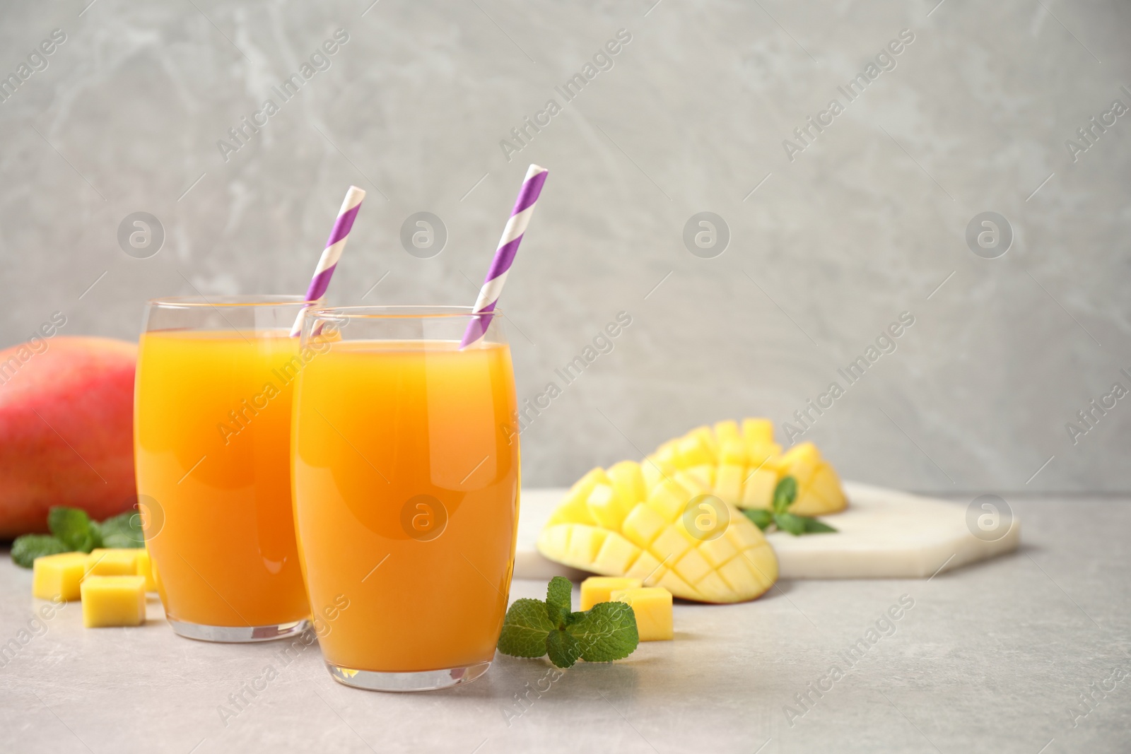 Photo of Fresh delicious mango drink on light table. Space for text