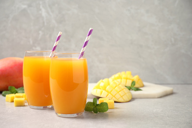 Fresh delicious mango drink on light table. Space for text