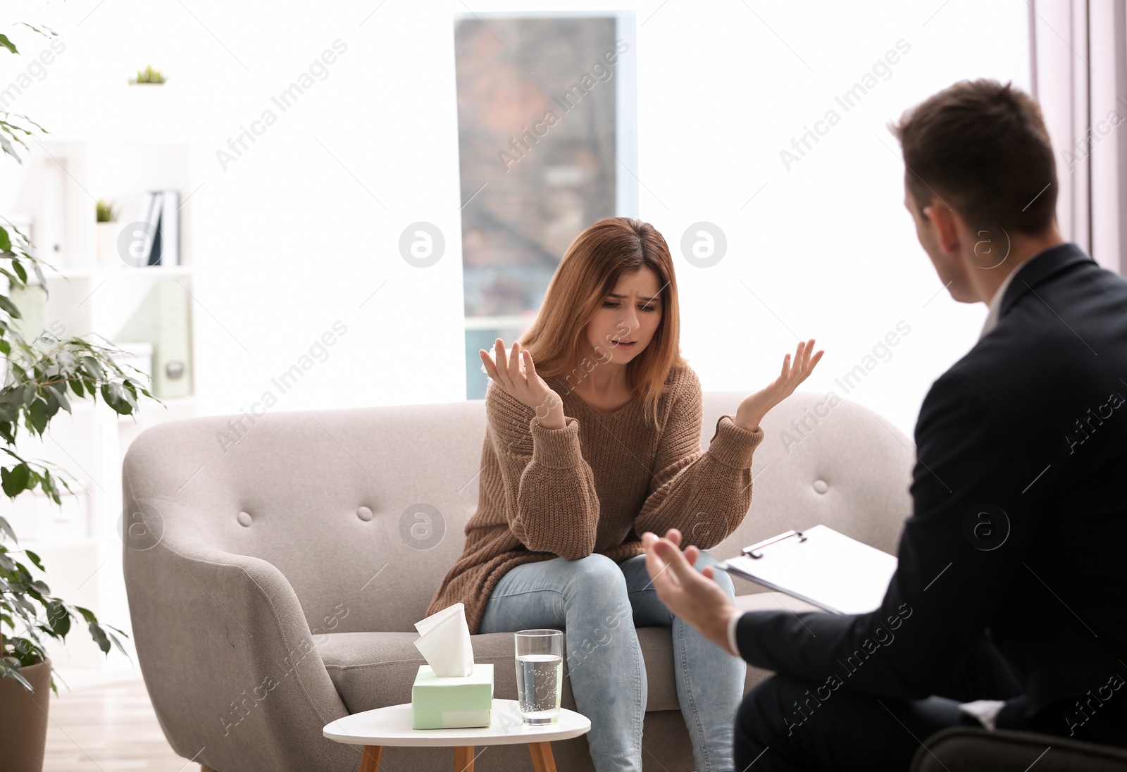 Photo of Psychotherapist working with woman in light office