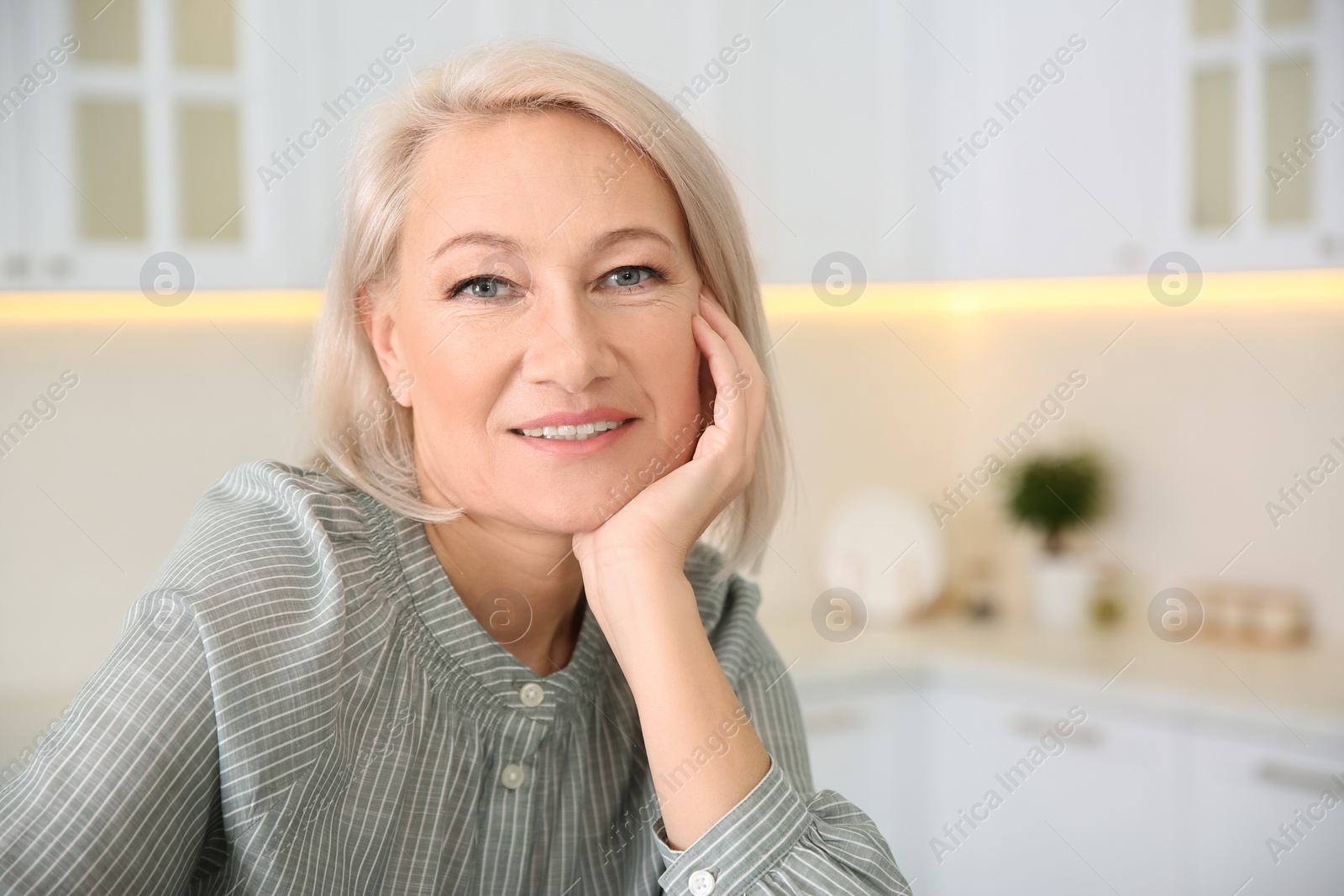 Photo of Portrait of beautiful mature woman in kitchen