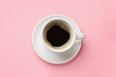 Photo of Fresh coffee in cup on pink background, top view