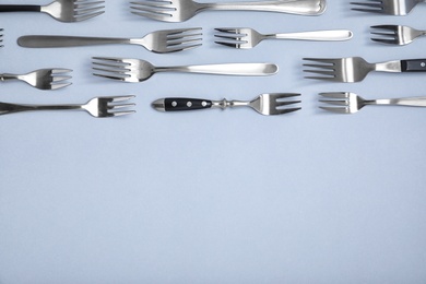 Set of different metal forks on white background, top view