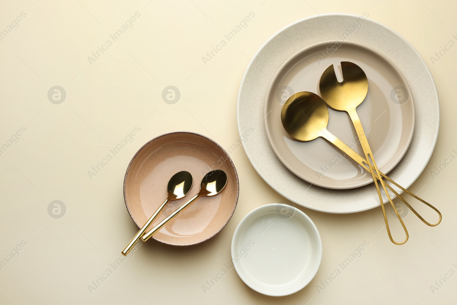 Photo of Stylish empty dishware and cutlery on beige background, flat lay