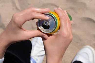 Photo of Woman opening can with sparkling drink at beach, closeup