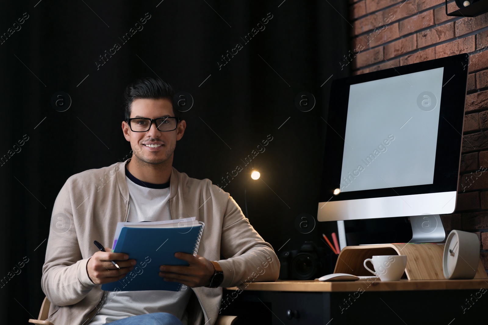 Photo of Journalist with notebook at workplace in office