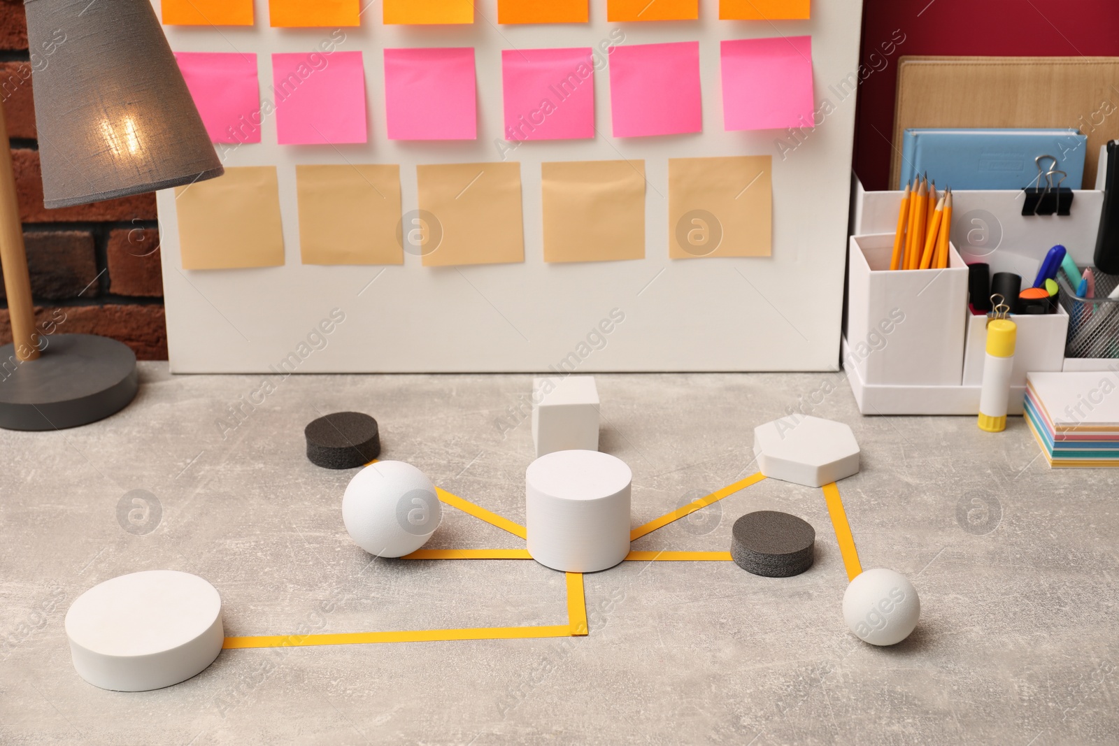 Photo of Business process scheme with geometric figures and stationery on light grey table