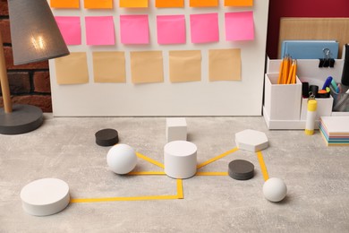 Business process scheme with geometric figures and stationery on light grey table