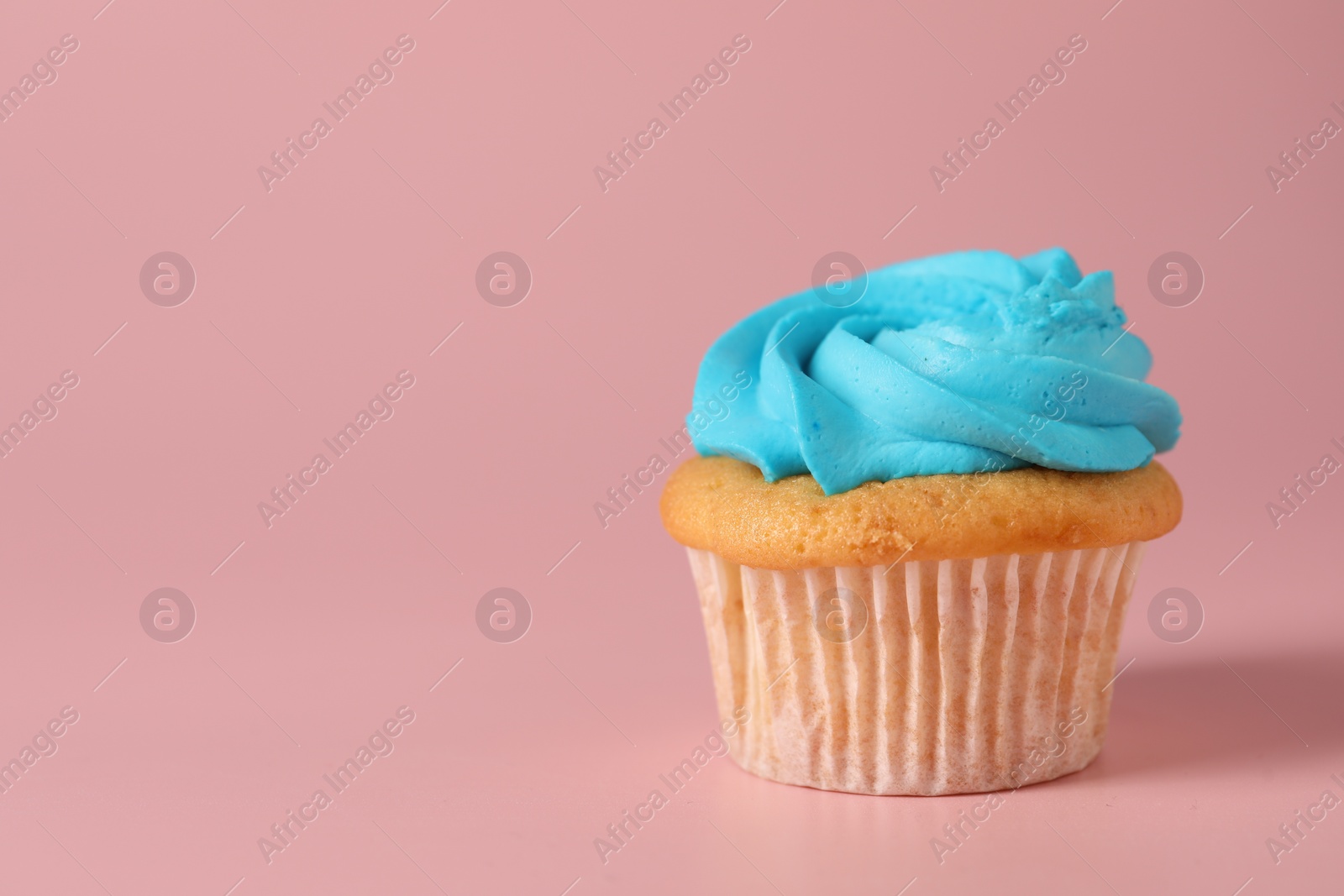 Photo of Delicious cupcake with bright cream on pink background, space for text