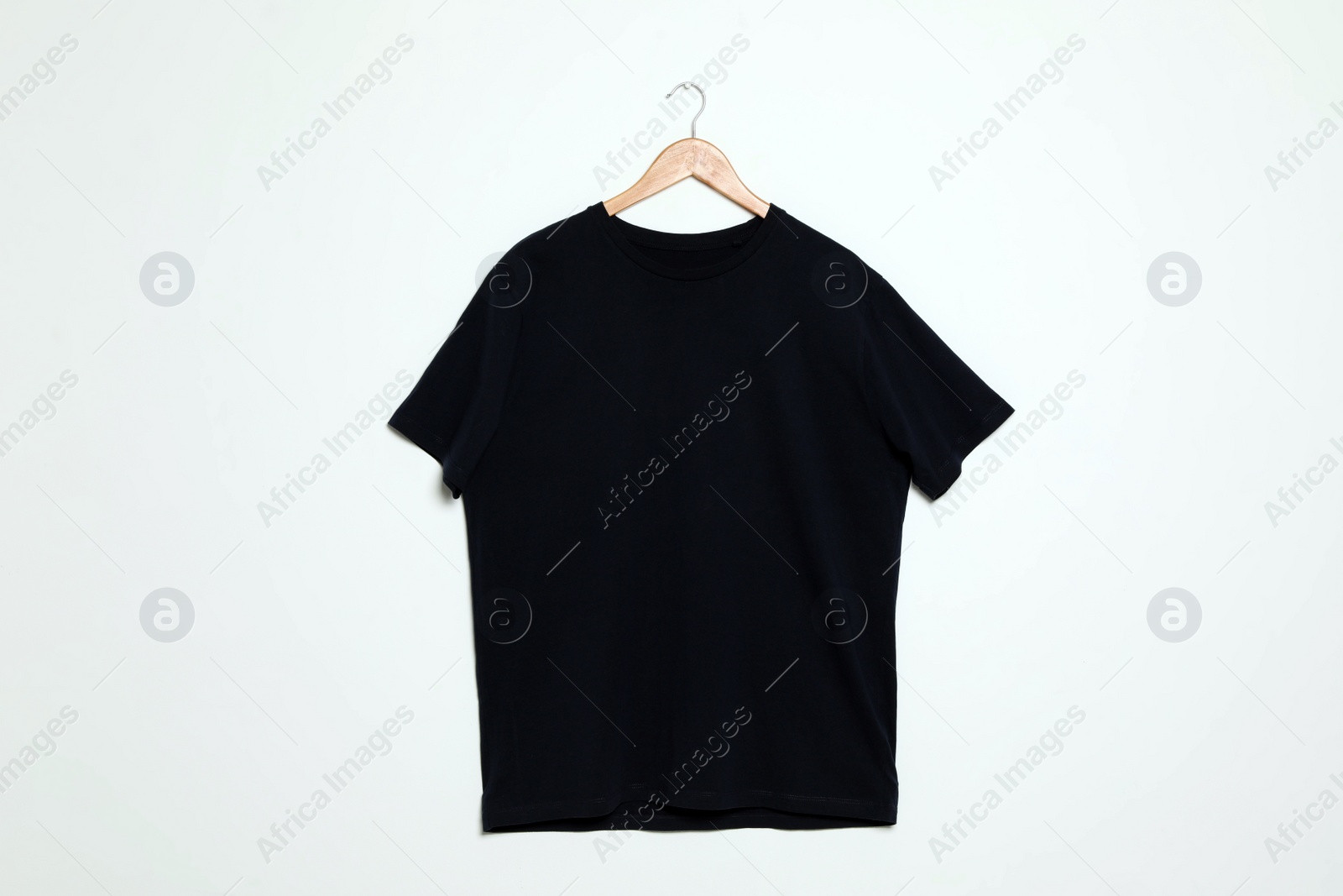 Photo of Hanger with blank t-shirt on white background. Mock up for design