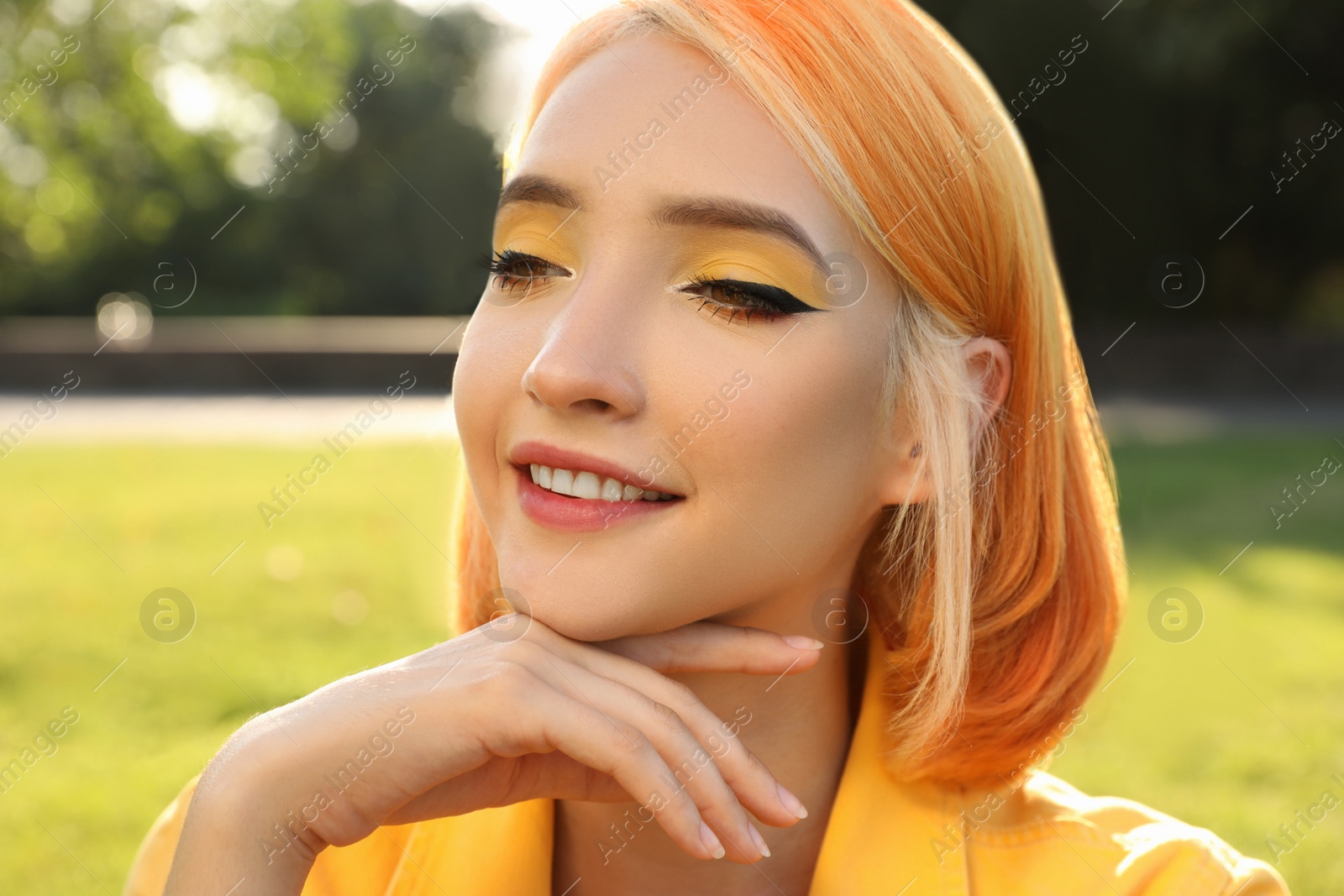 Photo of Beautiful young woman with bright dyed hair in park