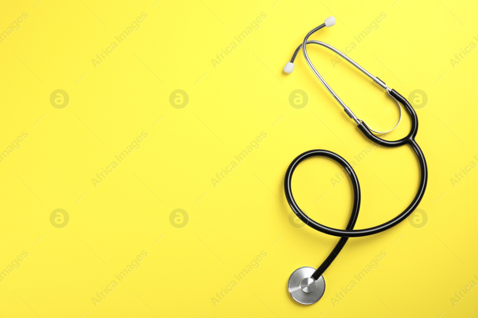 Photo of Stethoscope with space for text on color background, top view. Medical tool