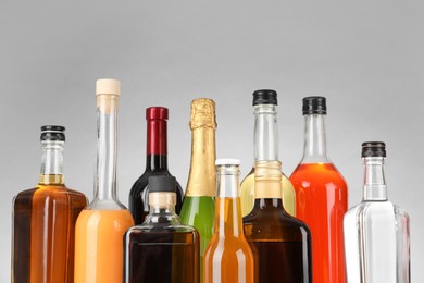 Photo of Bottles of different alcoholic drinks on gray background, closeup