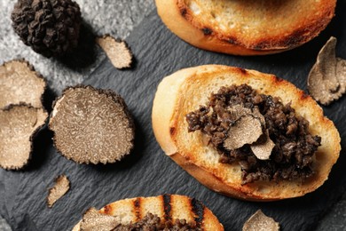 Photo of Delicious bruschettas with truffle sauce on grey table, flat lay